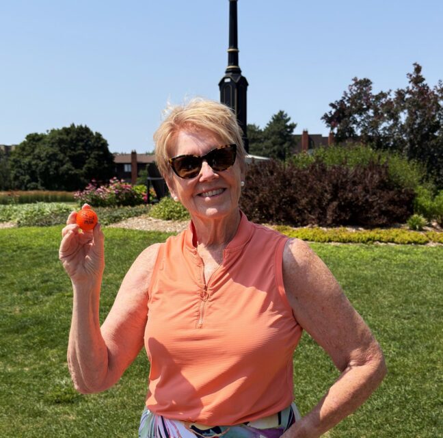 Catherine Potechin holding the ball from her first hole-in-one