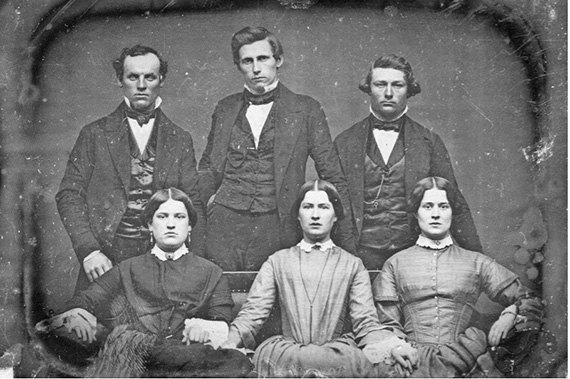Six unsmiling family members in a mid-1800s daguerreotype portrait