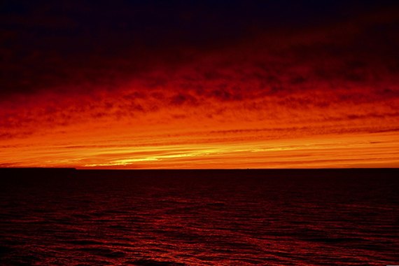 Deep red sunset over open water