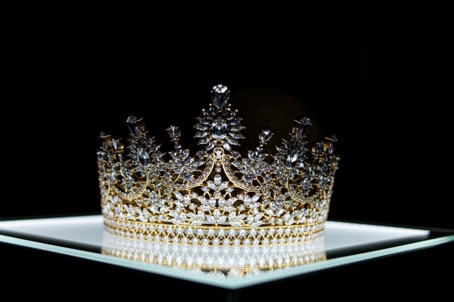 Jewelled gold and crystal crown on a dark display stand