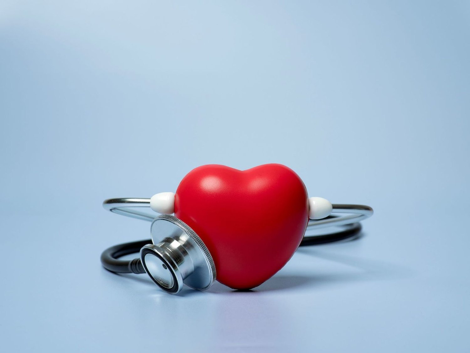 Red heart model beside a stethoscope