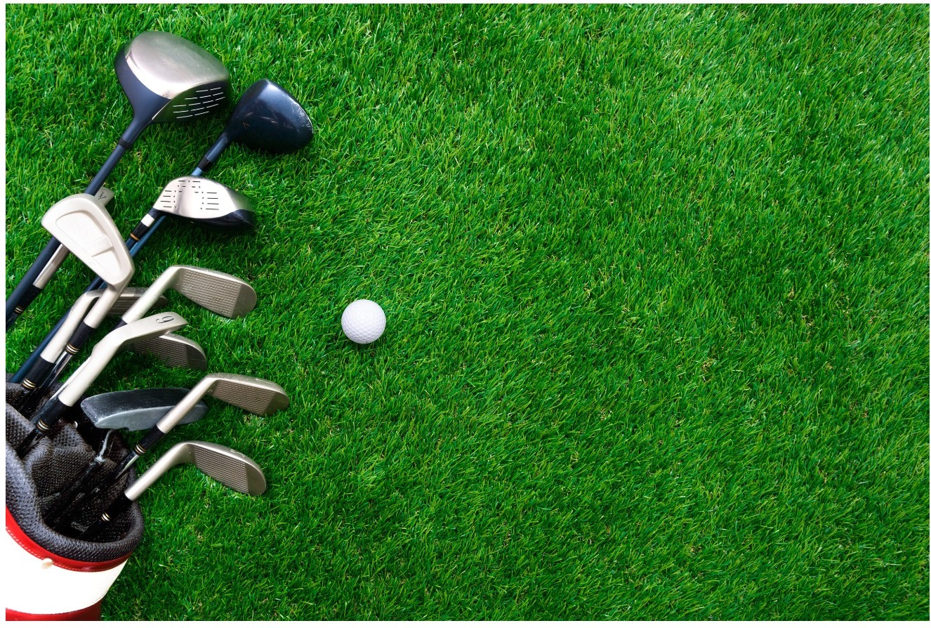 Golf bag with clubs and a golf ball on the putting green
